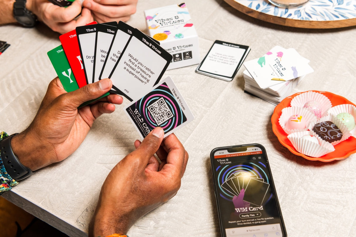 Hands holding YES, NO, and question cards during a game of Family Ties
